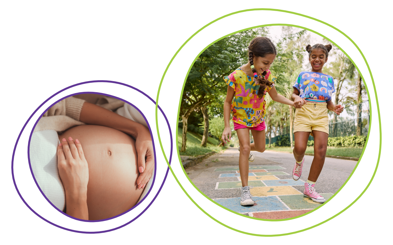 Pregnant woman gently touching her belly beside two children joyfully playing hopscotch outdoors